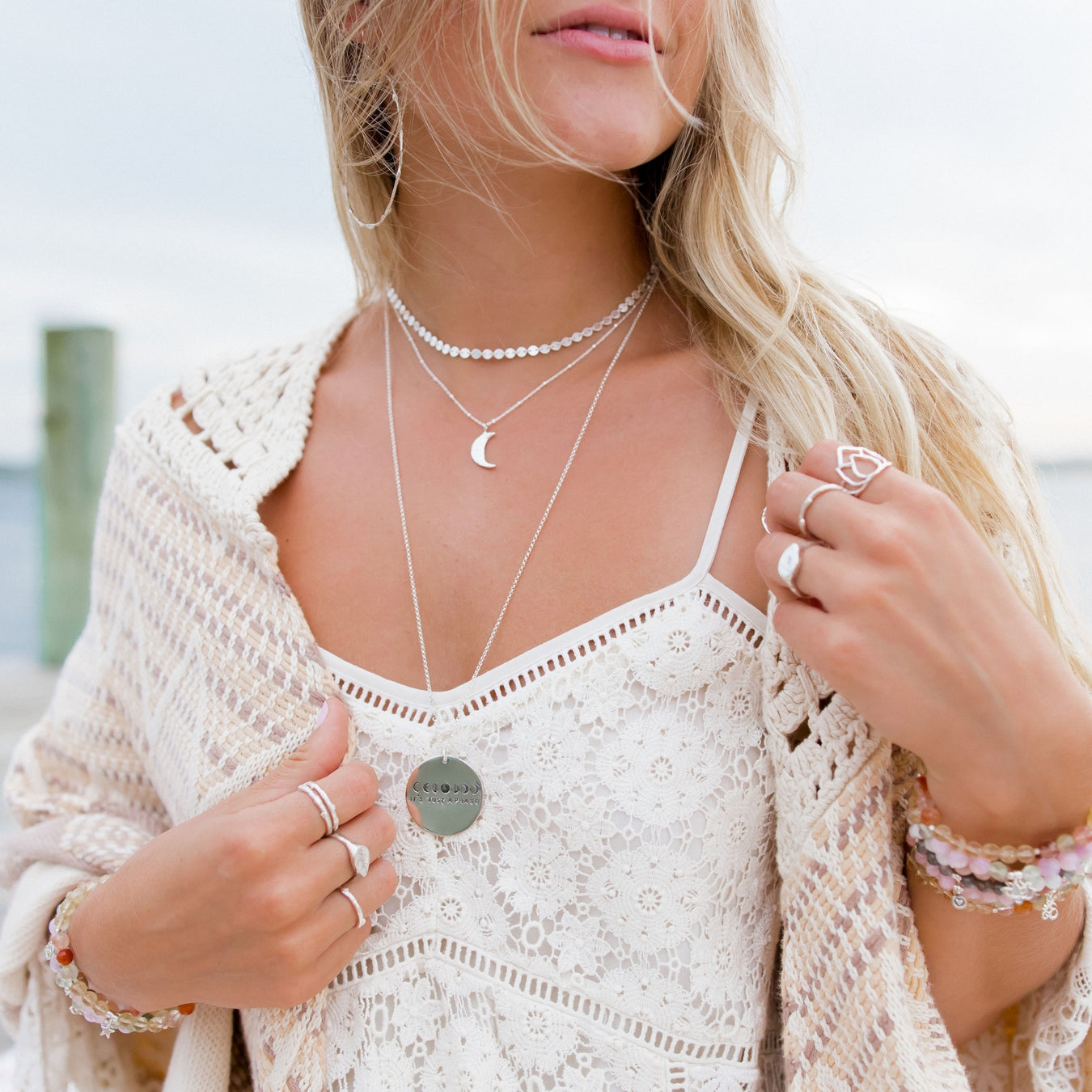 Blooming Lotus Jewelry - model wearing silver layering necklaces choker, crescent moon, mantra necklace on model wearing white lace dress