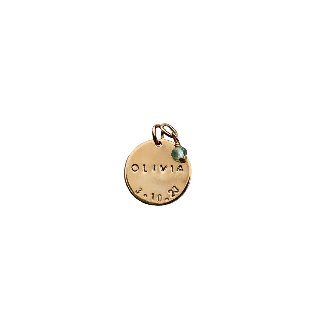 Gold add-on birthdate pendant with hand-stamped name and date, accented by an Aquamarine gemstone charm, from Blooming Lotus Jewelry.
