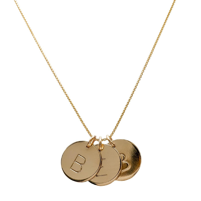 three gold initial disc coin pendants hanging from gold chain hand-stamped with capital B E and B