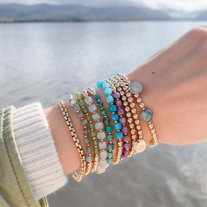 Gold Beaded Layering Chain Braceletes with gemstones and charms on wrist - Blooming Lotus Jewelry