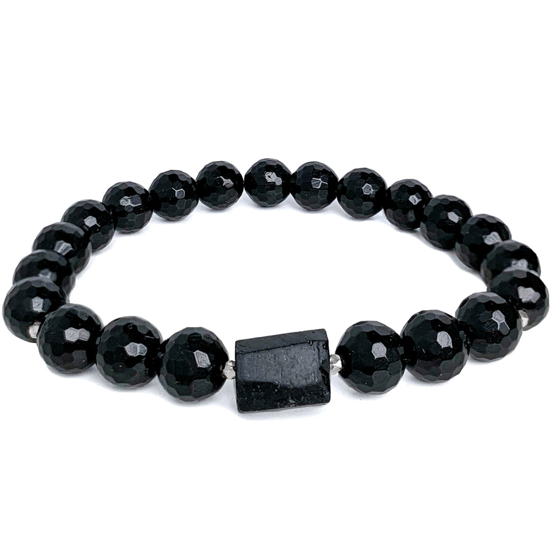 Black Tourmaline bracelet featuring faceted black tourmaline beads with a bold raw black Tourmaline center stone, strung on stretchy cord. The bracelet has a sleek, polished design, perfect for everyday wear and grounding energy. By Blooming Lotus Jewelry