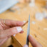close up of jewelry designer filing a gold bar pendant