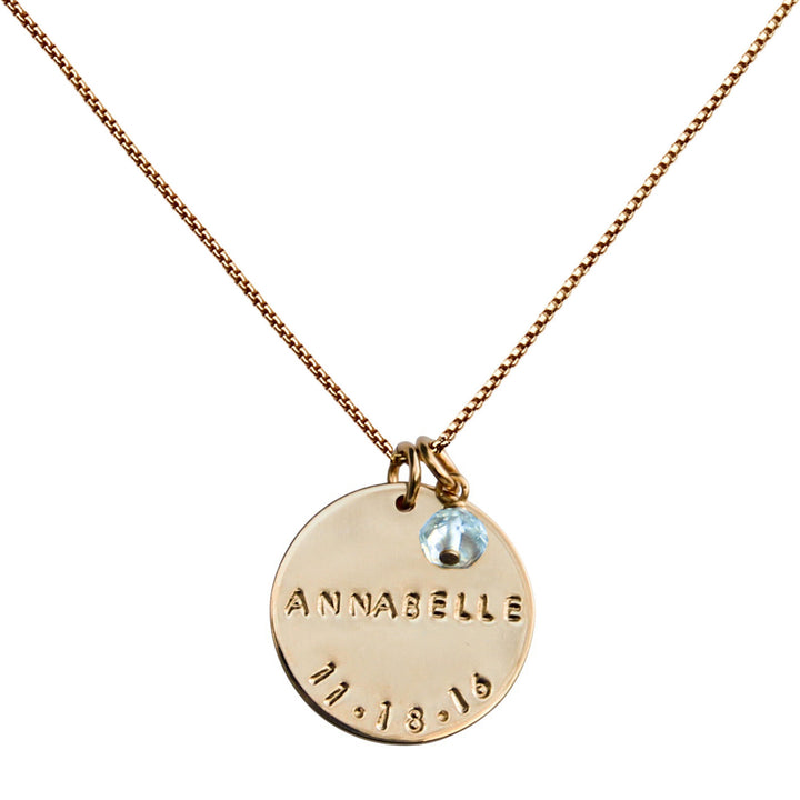 Large gold Birthdate Necklace with hand-stamped name and date on a 19mm disc, featuring an aquamarine birthstone. Handmade by Blooming Lotus Jewelry.