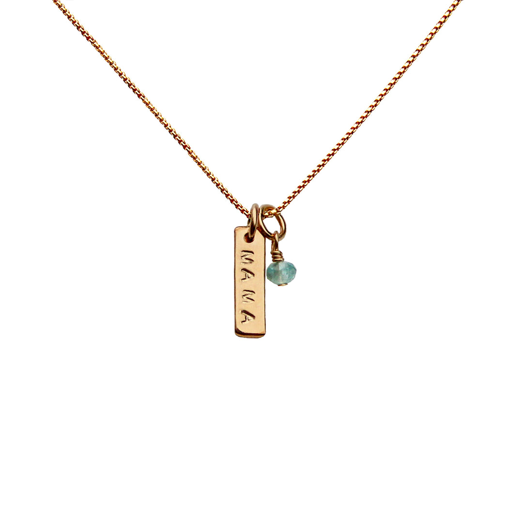Gold Micro Bar necklace stamped with “MAMA” and paired with a tiny aquamarine gemstone charm on a delicate chain — minimalist personalized jewelry by Blooming Lotus Jewelry.