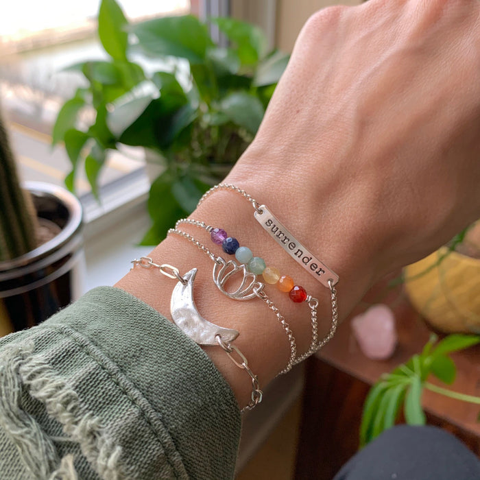 Chakra Rainbow Gemstone Bracelet with Lotus Luna Mantra Bar on silver chain on wrist close up - Blooming Lotus Jewelry