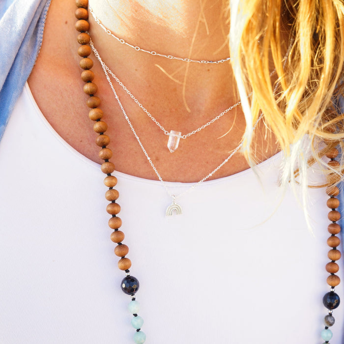 Clear Quartz and rainbow charm necklaces on model in sunlight - Blooming Lotus Jewelry
