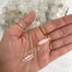 three clear quartz double terminated point crystals on silver and gold chain in palm of hand