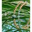 Gold Beaded Bracelets emerald cube gemstones hanging on plant leaves closeup - Blooming Lotus Jewelry