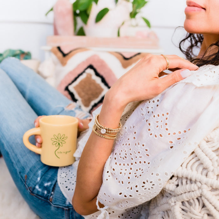 Gold Beaded Bracelets on model wrist holding coffee mug - Blooming Lotus Jewelry
