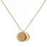 two gold initial disc coin pendants hanging from gold chain hand-stamped with capital B and Q