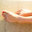 Gold Twinkle Anklet on model on sand with painted red toenails