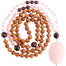rose quartz garnet sandalwood mala beads necklace coiled up top view with large rose quartz focal stone