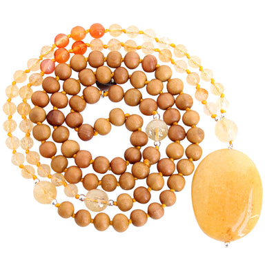 Citrine Carnelian Sandalwood mala beads coiled up with large yellow focal stone