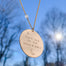 Gold Love You to the Moon and Back necklace on gold chain with tiny moonstone hand-stamped with sky in background