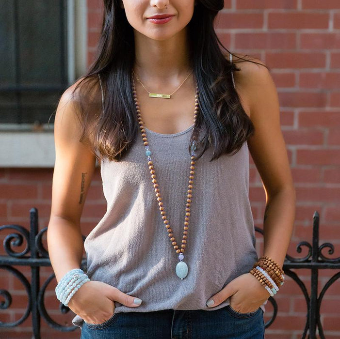 Mala beads necklace and mantra bar on model 