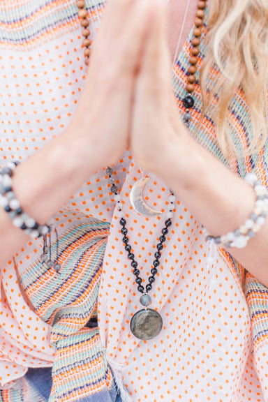 New Moon Mala Necklace closeup on model in prayer position - Blooming Lotus Jewelry