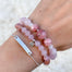 Soulmate bracelet with rose quartz heart charm bracelet and silver mantra bar chain bracelet on wrist close up