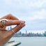Tiny Arrow Stud Earrings in hand with NYC background - Blooming Lotus Jewelry