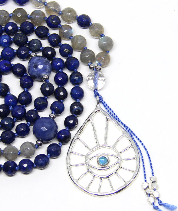 closeup silver evil eye pendant with london blue topaz on lapis lazuli and labradorite mala beads necklace