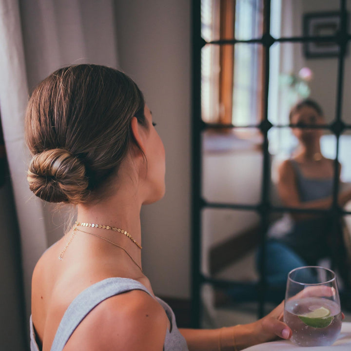 Back view of a woman wearing a gold-filled Herkimer Diamond choker necklace with adjustable extender and clear quartz gemstone detail.