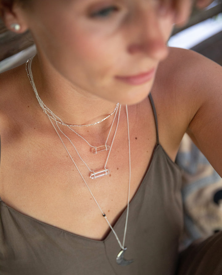 stacked clear quartz crystal necklaces on layered chains, boho coastal jewelry styling with double terminated quartz pendants